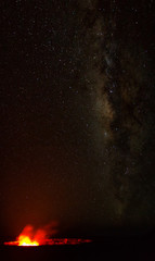 Ein Lavasee im  Halemaumau Krater auf dem Kilauea beleuchtet aufsteigende vulkanische Dämpfe vor der Milchstraße im Nachthimmel im Hawaii Volcanoes National Park auf Big Island, Hawaii, USA.