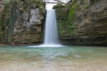 Fototapeta na wymiar Wasserfall mit See und Steinwand