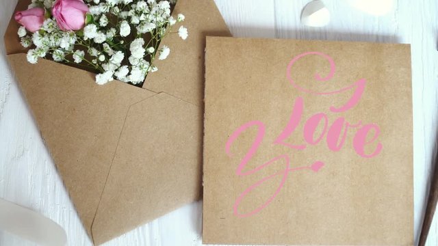 I Love You Vintage Written animation text on kraft envelope on white wooden background. Calligraphy and lettering flourish elements for Valentines Day wedding or other holidays