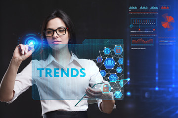 The concept of business, technology, the Internet and the network. A young entrepreneur working on a virtual screen of the future and sees the inscription: Trends