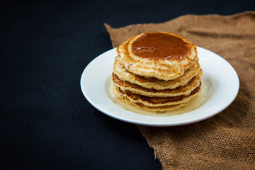 appetizing pancakes with honey on a dark table. Menu , restaurant recipe concept. Served in.