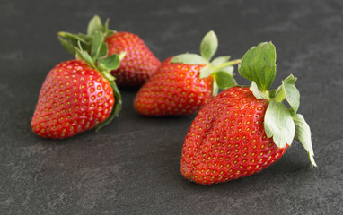 Ripe juicy strawberries on a gray background.