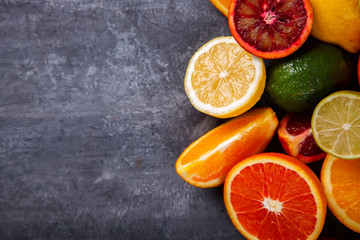 Different Citrus Fruit on a Grey Background .Mixed Colorful Tropical Background.Food or Healthy diet concept.Vegetarian.Copy space for Text. selective focus.