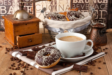 Cup of coffee with milk   and chocolate donut on a wooden table