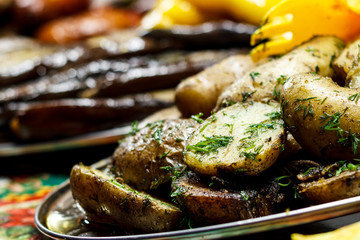 Freshly fried potato wedges with herbs and garlic on a baking sheet