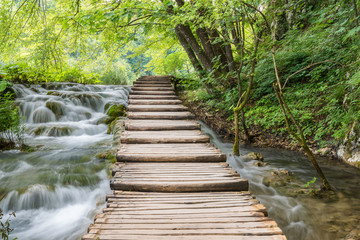 Plitvice Lakes National park, tourist route on the boardwalk along streams and waterfalls. Green summer landscape, famous landmark in Croatia