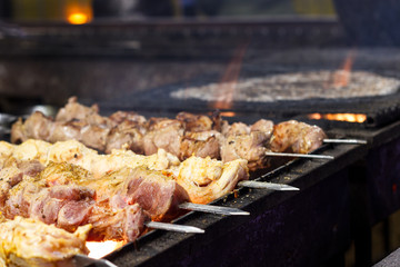 The process of cooking shish kebab on a metal grill in the open air.Grilling shashlik on barbecue grill. Marinated meat.