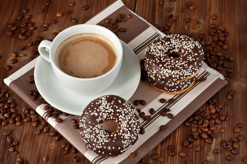 Fresh donuts with hot drink on wooden table