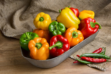 Red, green and yellow sweet bell peppers on table,