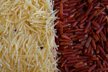 Pasta Vermicelli or macaroni with brown wholemeal rice texture background Traditional Italian food The concept of proper nutrition and healthy lifestyle. Top view, close-up as background or texture