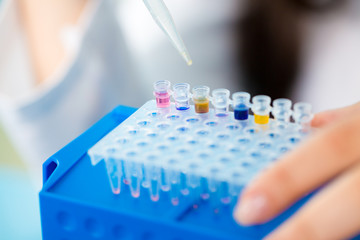 Young female technician in genetic laboratory with PCR