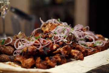 shish kebab with red onion and glasses of champagne