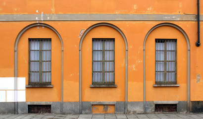 Window bars and closed windows on an orange ocher wall