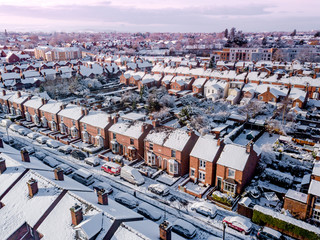Aerial view of snow covered traditional housing suburbs in England. Snow, ice and adverse weather...