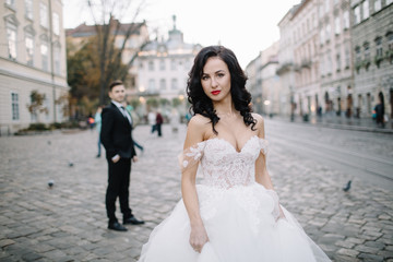 Fototapeta premium Bride and groom walking through the old town