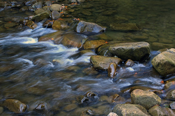 Fototapeta na wymiar Stones and mountain river with small waterfall