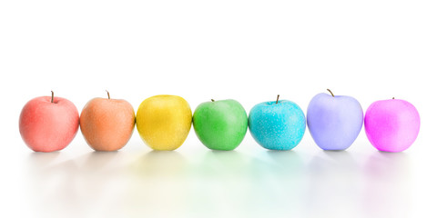 Row of different rainbow colored apples isolated with clipping path