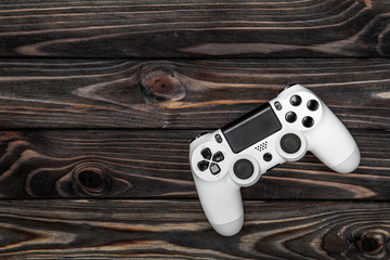 white gamepad on a dark wooden background © solidmaks