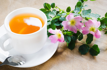 Cup of morning tea with lemon and delicate flowers