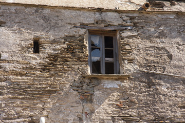 Fototapeta na wymiar Old stone house broken windows Andros Greece
