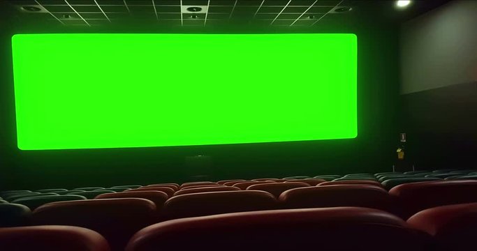 cinema interior of movie theatre with empty red seats with copyspace on the chroma key green screen and glow on edge, zoom in effect, concept of recreation and entertainment