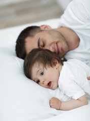 father and baby sleeping peacefully in bed