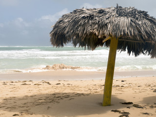 Fototapeta na wymiar Umbrella of palm leaves on the beach