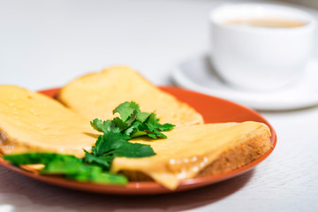Breakfast of cheese sandwich and cup of coffee