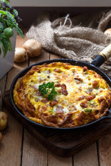 Baked omelette with bacon and cheese in a pan, close view
