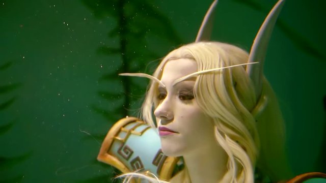 Close up shot of a beautiful blonde girl elf living in water. Interesting clothes, fantastic look.