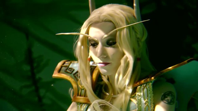 Close up shot of a lovely blone elf lonely floating under water on its back. Beautiful blonde hairs take a fantastic forms.