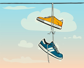Sneakers hanging from a rope on the background of clouds