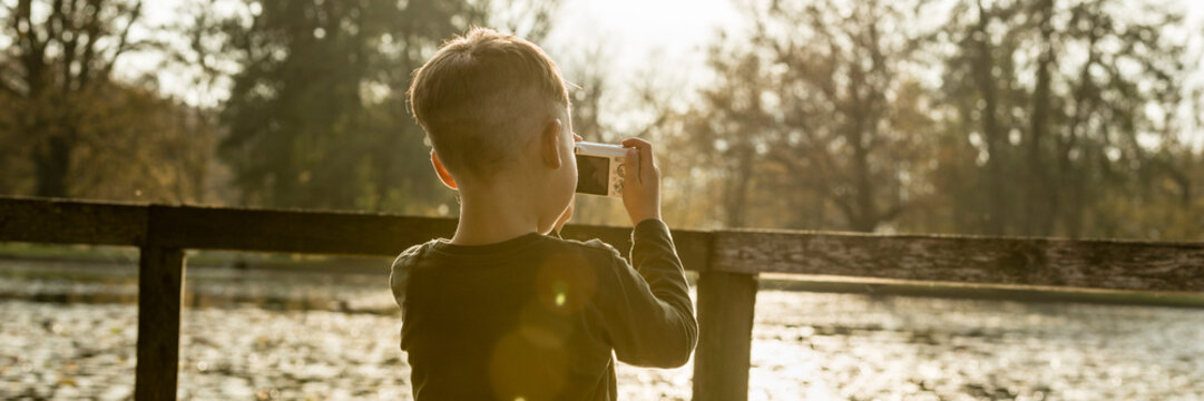 Little boy photographing nature
