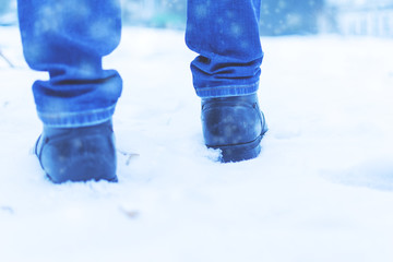 A man walks in the snow. Men's shoes. Close up.