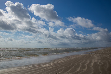 Sunny day on the beach with white clouds in the sky