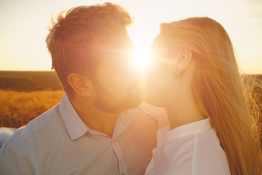 Couple kissing on the background of a sunset 