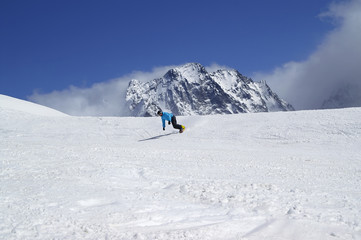 Fototapeta na wymiar Snowboarder downhill in high snowy mountain