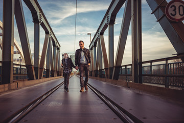 Father and daughter walking across the freight bridge