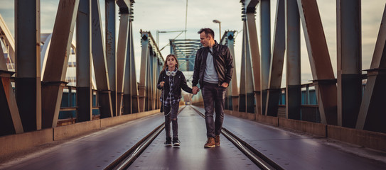 Father and daughter walking across the freight bridge