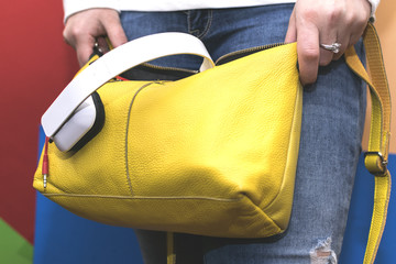 The girl searches for something in his bag. Women's handbag.