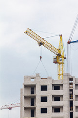 Building crane under construction against blue sky