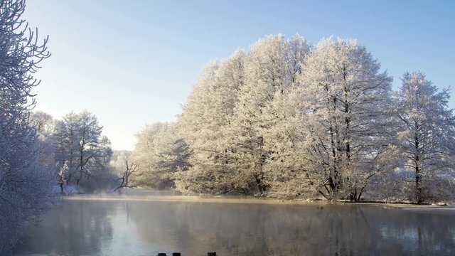 Winter river landscape. Beautiful dawn in the winter park, time-lapse 4K.
