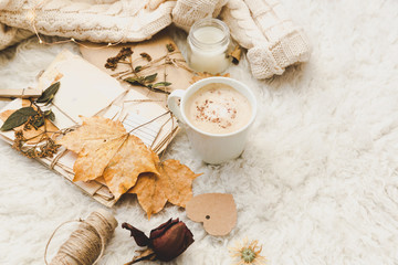 Winter cozy background with cup of coffee, warm sweater and old letters