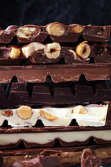 Chocolate bars on dark background with chocolate tower