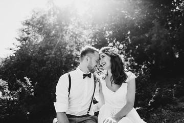 Attractive couple laughing on a sunny day. Over them the rays of the sun. Black and white photo