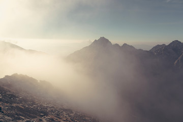 Mountain peaks in Tatra mountains and fog. Photography in pastel colors.