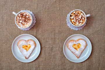 Cheese pancake in the form of a heart and a cup of coffee with marshmallows. Romantic breakfast.	