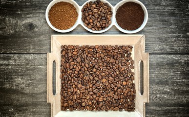 Caffeine design concept-ground coffee, instant coffee and coffee beans on a wooden background.