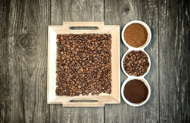Caffeine design concept-ground coffee, instant coffee and coffee beans on a wooden background.
