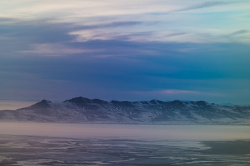 Interesting looking snow covered mountains of Utah in the afternoon just after a blizzard. The light coming into the plane window created an interesting array of colors. 